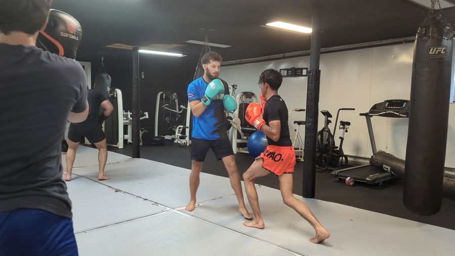 Coach Elijah Halloun in his stance, working with a student at Fight Mechanix